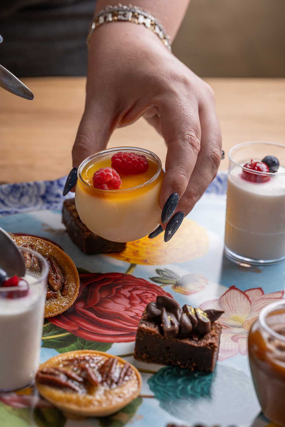 מגוון קינוחים מתוכם אישה מחזיקה קינוח